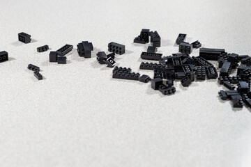 Grupo de bloques plásticos negros regados en fondo claro 