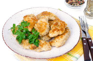 Breaded chicken fillet pieces on plate