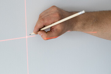 A specialist marks a point on a wall with an electronic laser