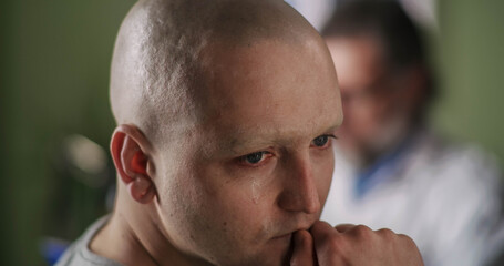 Naklejka premium Bald man reacting to band news and talking with oncologist