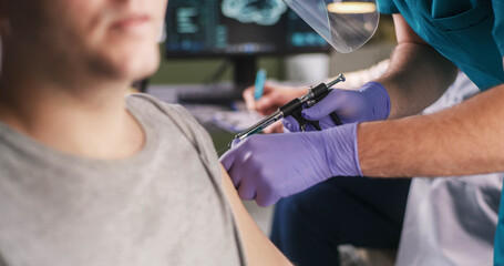 Crop doctor injecting vaccine into shoulder of man