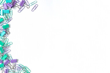 Multi-colored paper clips on a white background. Place for your text. Top view.