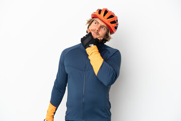 Young blonde cyclist man isolated on white background having doubts