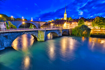Aare river flows under bridges of Bern old town with view of Nydeggkirche church.Capital of...
