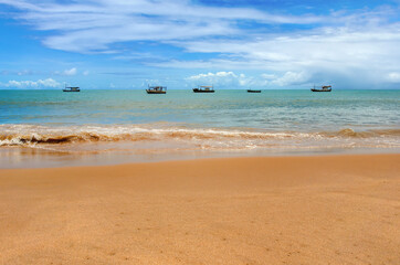 Fototapeta na wymiar View from the sandy beach on five fishing boats at sea.