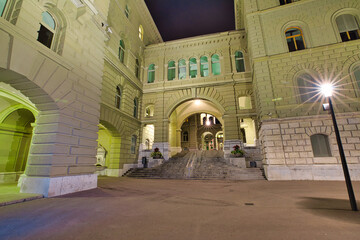 Archades and stairway of Federal Palace in Bern, Switzerland. Swiss Parliament building skyline by night. Landmark of historical old town Bern, Capital of Switzerland.
