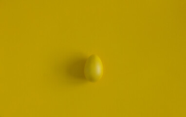 Yellow Easter egg on a yellow background. Background for design. Easter background. Easter.Copy space.