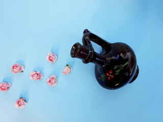 Blue pastel background with carafe and small pink roses