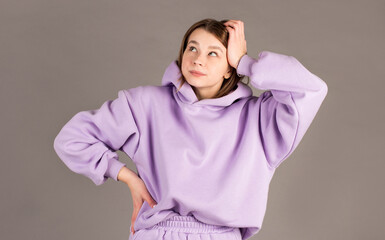 Beautiful female with puzzled expression, keeps hand on head, looks aside with bewilderment, poses...