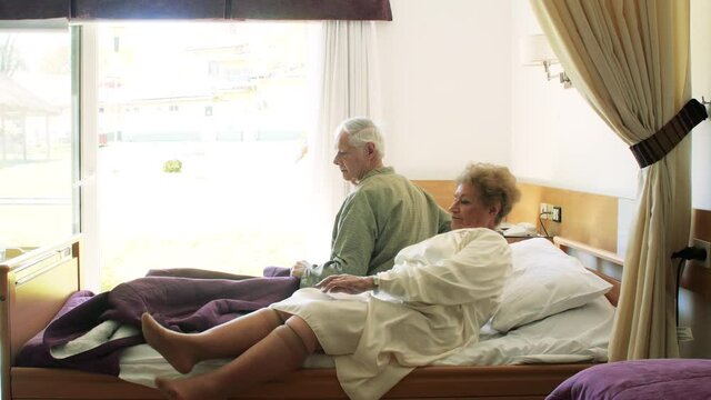 Two elderly people going to bed in hospital rehab clinic