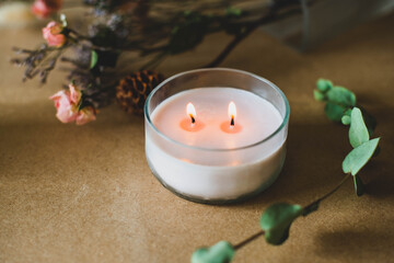 wooden wick candle. Handmade candle from paraffin and soy wax in glass with flowers and leaf on...