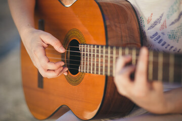 Close-up of female hands playing classical guitar