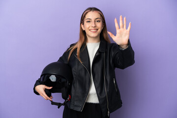 Fototapeta na wymiar Young caucasian woman holding a motorcycle helmet isolated on purple background counting five with fingers