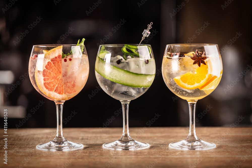 Wall mural gin tonic long drink as a classic cocktail in various forms with garnish in individual glasses such 