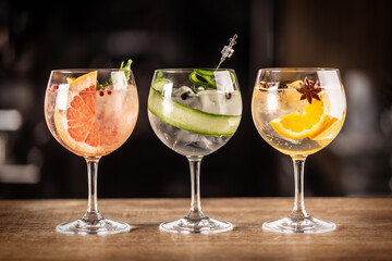 Gin tonic long drink as a classic cocktail in various forms with garnish in individual glasses such as orange, grapefruit, or cucumber