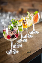 Gin tonic long drink as a classic cocktail in various forms with garnish in individual glasses such as orange, lemon, grapefruit, cucumber or berries