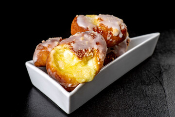 Tasty cakes with liqueur in a white bowl. Dessert prepared to be served on the kitchen table.