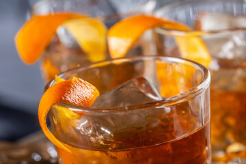 Old fashioned rum drink on ice with orange zest garnish