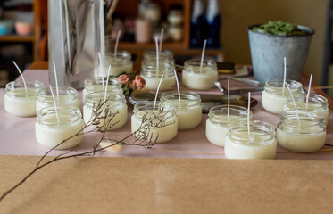 Many soy wax candles together on store or workshop background. pottery store. Ecological and vegan business. Soya wax candle accessories. Handmade with love. Remote work, online shop, workplace