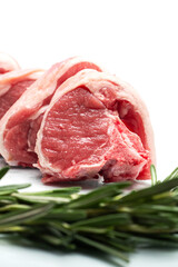 Fresh lamb loin chops on white background with green rosemary herb. Meat industry product