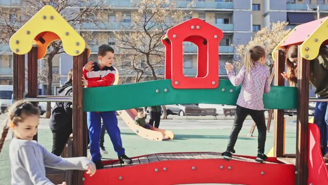Group of children playing on jungle gym and having fun at sunny autumn day. High quality FullHD footage