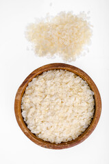 Fototapeta na wymiar Wooden bowl of flattened rice flakes isolated on white background