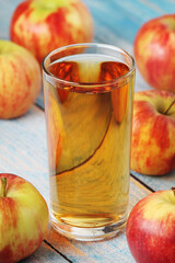 A glass with apple juice and ripe apples	