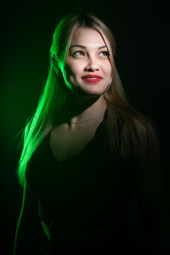 Portrait Of A Blonde Girl With Bright Makeup In Green Light