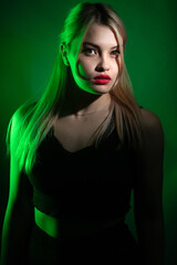portrait of a blonde girl with bright makeup in green light