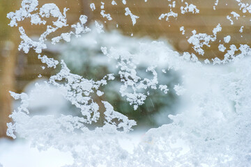 Snow and ice on a window glass looking into a snowy garden in winter, Almere, Flevoland, The Netherlands, February 7, 2020