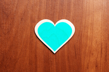 turquoise wooden heart symbol on wooden background. valentine greeting card concept. above view