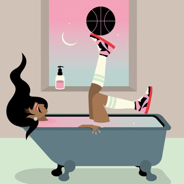 Person relaxing in a bath playing with a basketball