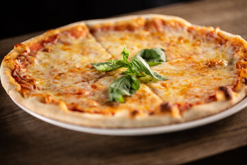 Quattro formaggi pizza with four types of cheeses, crusty edges and fresh basil on top