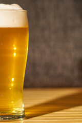 Light foam beer in a glass with a blurred background.