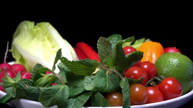 Vegetarian healthy food, vegetables: cucumbers tomatoes peppers and others on a rotating plate