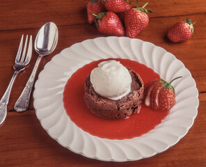 
Petit Gateau with ice cream, strawberry and strawberry sauce on white plate