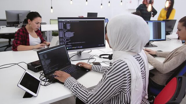 Muslim developer woman wearing vail sitting in coworking office and programing new source codes