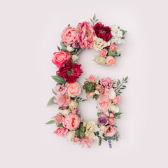 Letter G made of real natural flowers and leaves. Flower font concept. Unique collection of letters and numbers. Spring, summer and valentines creative idea.