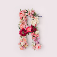 Letter R made of real natural flowers and leaves. Flower font concept. Unique collection of letters and numbers. Spring, summer and valentines creative idea.