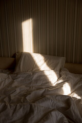 Sunbeam falls on the bed. The sun rays through window in the morning. New Day with Warm Sunlight Flare.