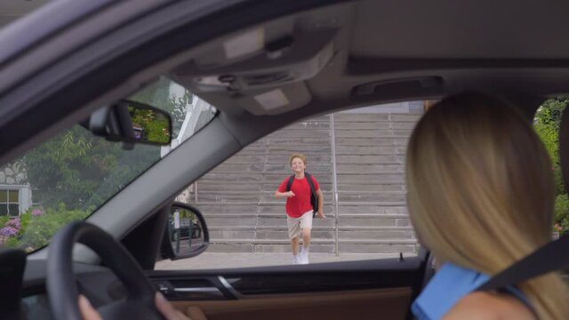 Young Boy Runs Down the Steps as His Mother Pulls Up Car in Front of School