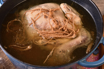 Ginseng chicken soup in cast iron pot.