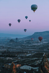 Hot air balloon flying over rock landscape at Cappadocia Turkey. Vertical image.