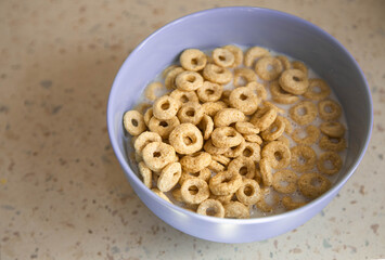 Delicious crunchy cereal loops in blue bowl on the table. Healthy, low-carb, gluten free breakfast