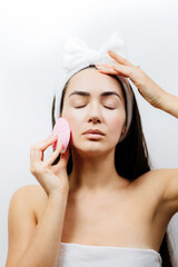 happy woman using electric cleansing brush for face deep cleaning. Beautiful naked woman clean face with cleansing brush. 
