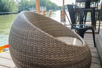 Obraz na płótnie Canvas close up rottan chair at riverside restaurant for seat