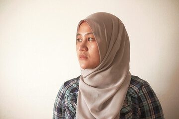 Asian muslim woman wearing hijab looking to the side with neutral expression, diverse people...