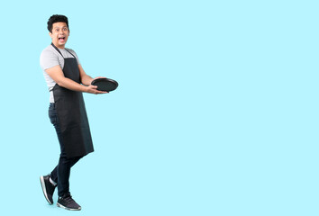 Dining concept. Asian man waiter holding an empty plate.isolated on blue background in studio With copy space.