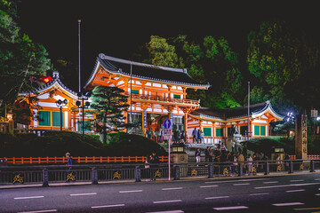 The great gate and entrance building of the Yasaka shrine with visitors in night, Kyoto, Japan