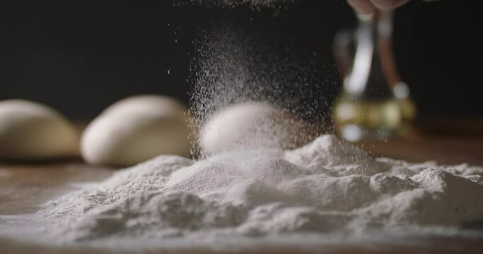 Close up shot of sifting white flour onto wooden table with a sieve. Preparation for making bread in bakery. Food and drink, healthy food 4k footage